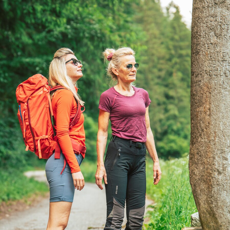Zwei Wanderer begutachten den Ehrenburger Meilenstein | © HERB -Media vGmbH