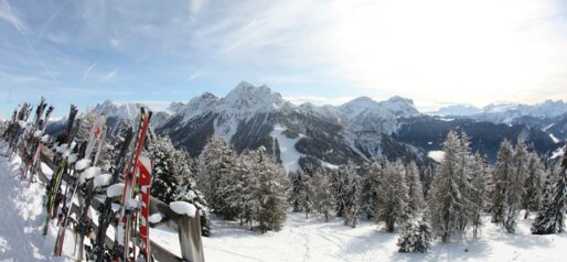 Skier am Zaun mit Bergpanorama | © Ski Kronplatz