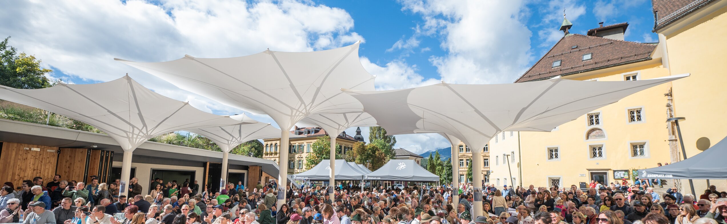 Das Publikum beim Speckfest genießt die warmen Sonnenstrahlen und feiert. | © Gianvito Coco