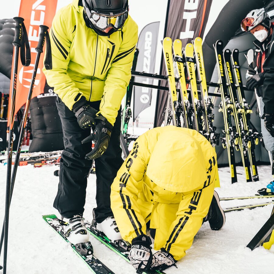 Eine Person stellt einer anderen Person die Skier ein. | © Skirama Kronplatz