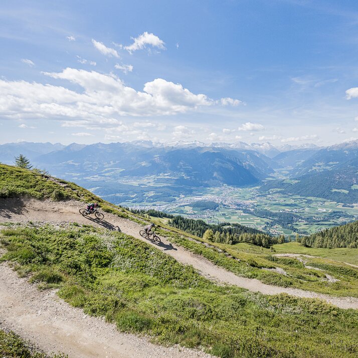 Eine Mountainbikerin und ein Mountainbiker unterwegs auf den Trails im Kronplatz Bike Park. | © Harald Wisthaler